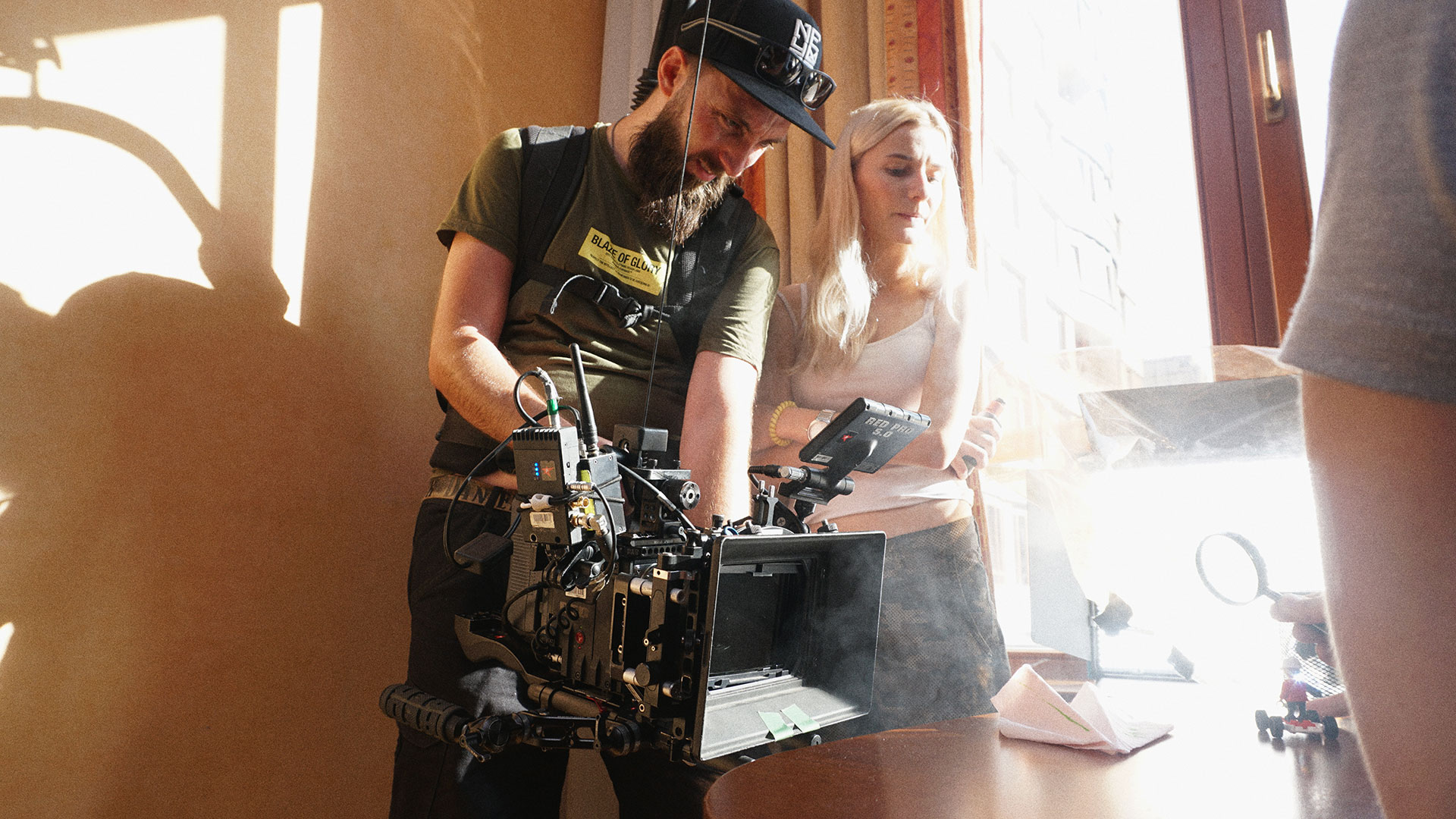 Videographer Yuri is capturing the moment the toy plane catches fire while our artist, Vika Yanchuk, creates smoke using a vape. The smoke is necessary so that the light beam from the magnifying glass can be seen in the video.